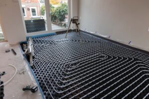De slangen van de vloerverwarming zijn vastgemaakt aan de noppenplaat. Het aanbrengen van de dekvloer kan beginnen.